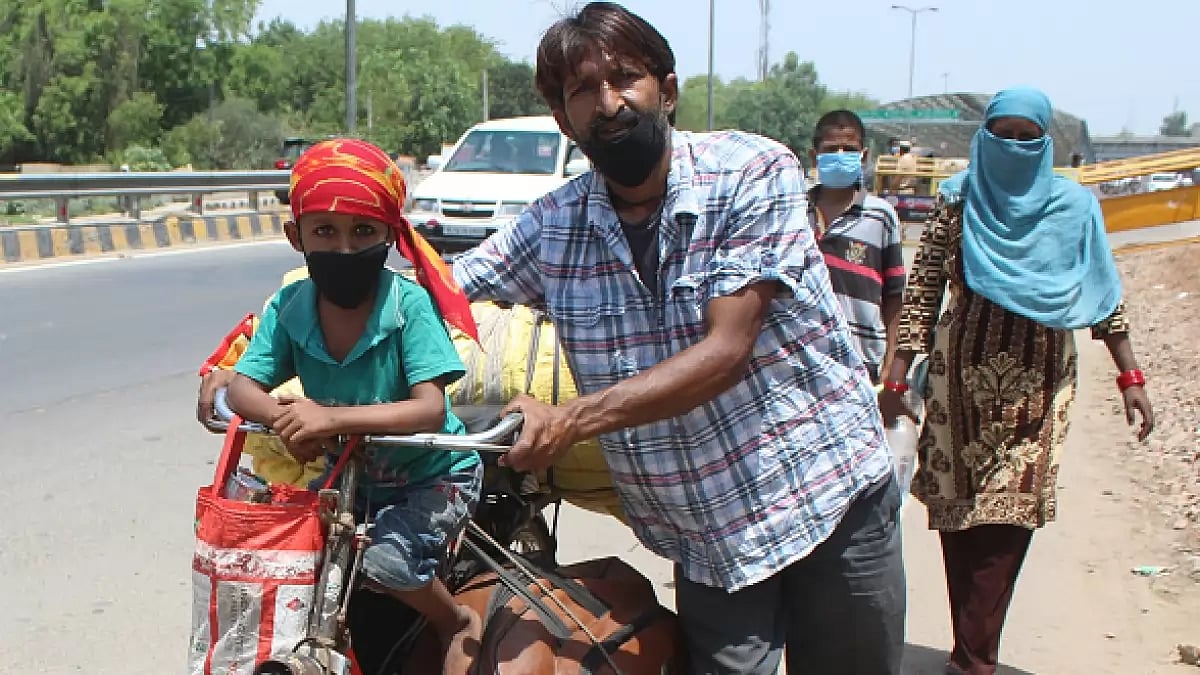 GURUGRAM, INDIA - MAY 15: A family of migrants with their belongings piled on a bicycle heads back home to Madhya Pradsh, near Tau Devi Lal stadium, on May 15, 2020 in Gurugram, India.