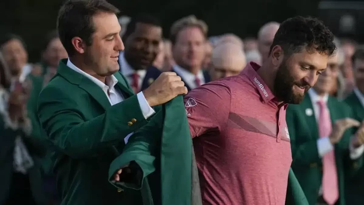 Scottie Scheffler (L) puts the green jacket on Jon Rahm of Spain, after the latter won the Masters.