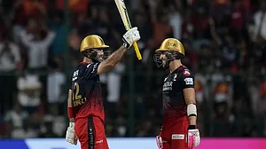 Glenn Maxwell raises his bat after reaching his half-century in Bengaluru on Monday.