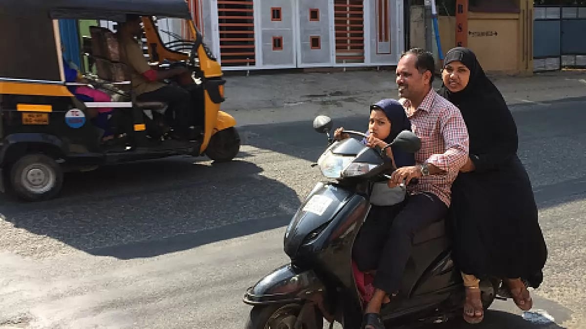 Man travels with his wife and daughter on a scooter in the city of Thiruvananthapuram (Trivandrum), 