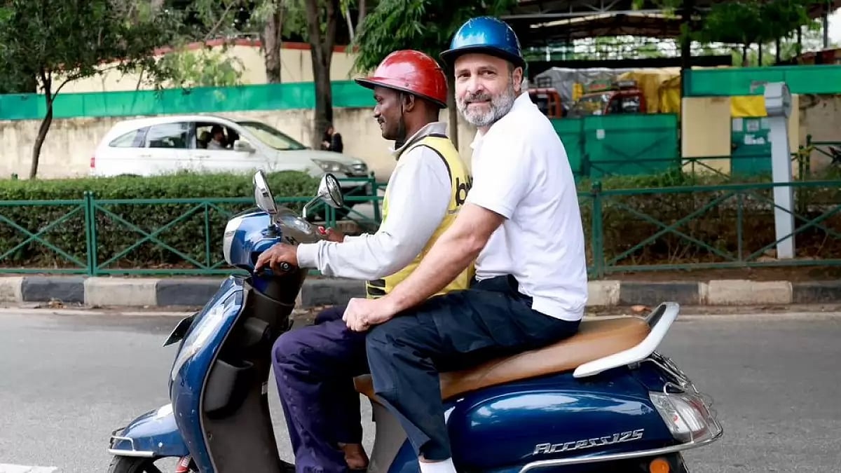 Congress leader Rahul Gandhi rides with a gig worker in Bengaluru