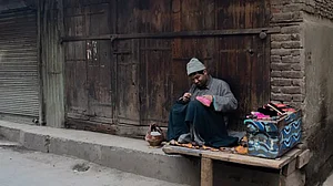 Kashmiri cobbler mends a shoe on a porch of a shop in the old city, on February 05, 2019 in Srinagar