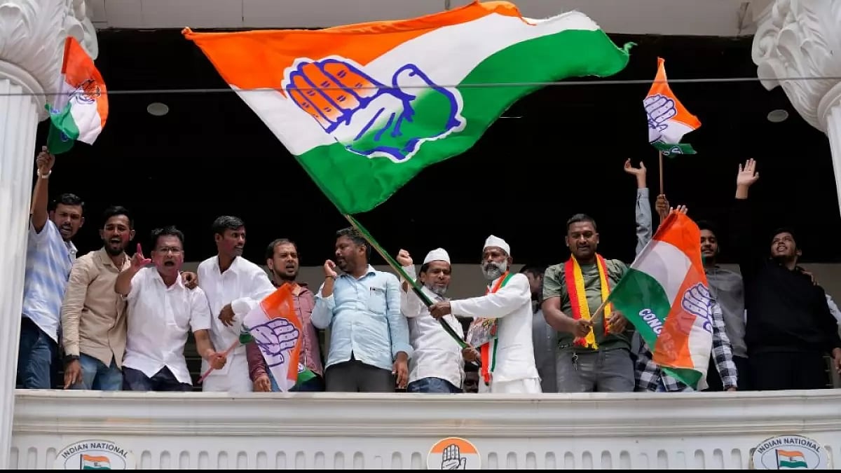 Congress supporters wave flags to celebrate early leads in Karnataka