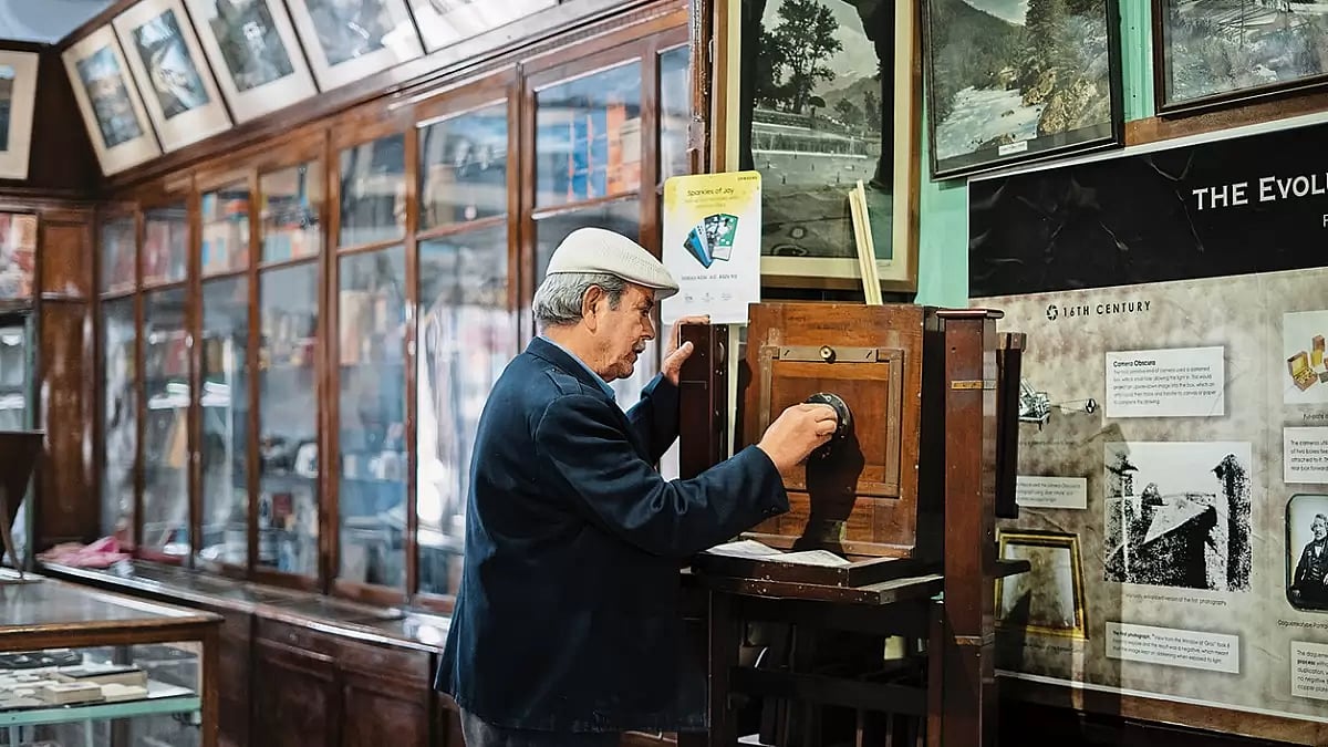 Old is Gold: Ghulam Muhammad adjusts the lens of a wooden retro camera which was used to shoot portraits earlier
