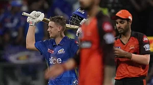 Cameron Green raises his bat after reaching his maiden T20 hundred in Mumbai on Sunday.