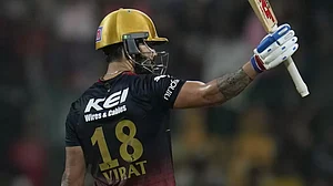 Kohli raises his bat after reaching his hundred against GT in Bengaluru on Sunday.