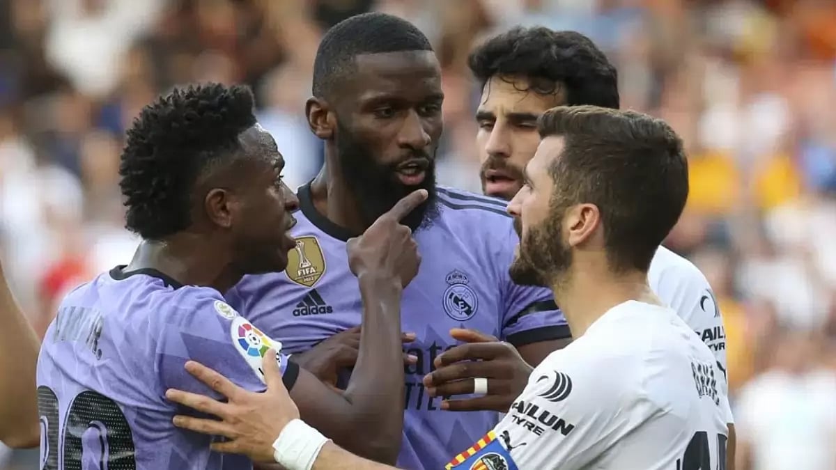 Vinicius Jr points at the crowd after being subjected to racist attacks.