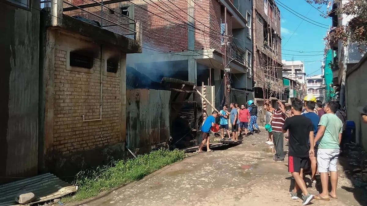 People try to douse a fire that broke out amid clashes between armed groups and security forces