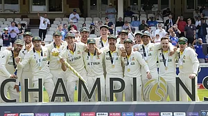 The Australian team celebrate as captain Pat Cummins holds the winners trophy.