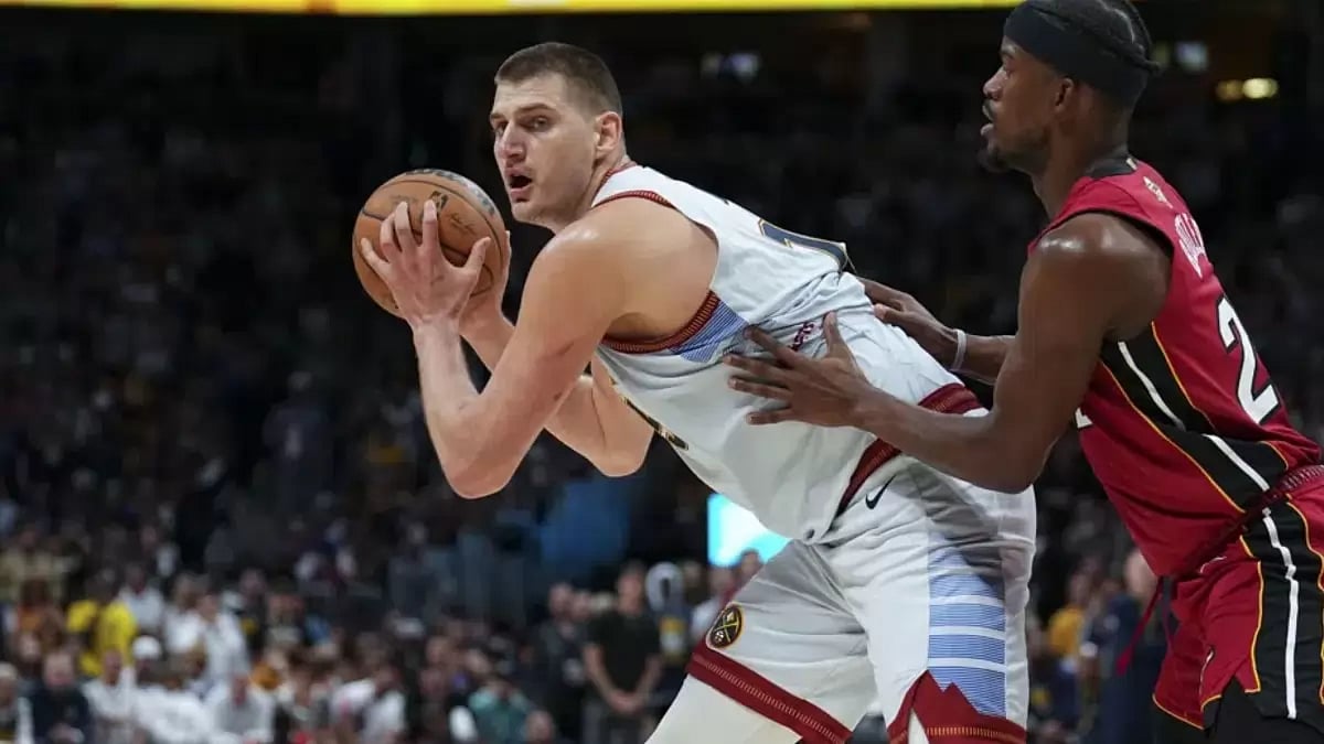 Denver Nuggets center Nikola Jokic (L) is defended by Miami Heat forward Jimmy Butler (R).