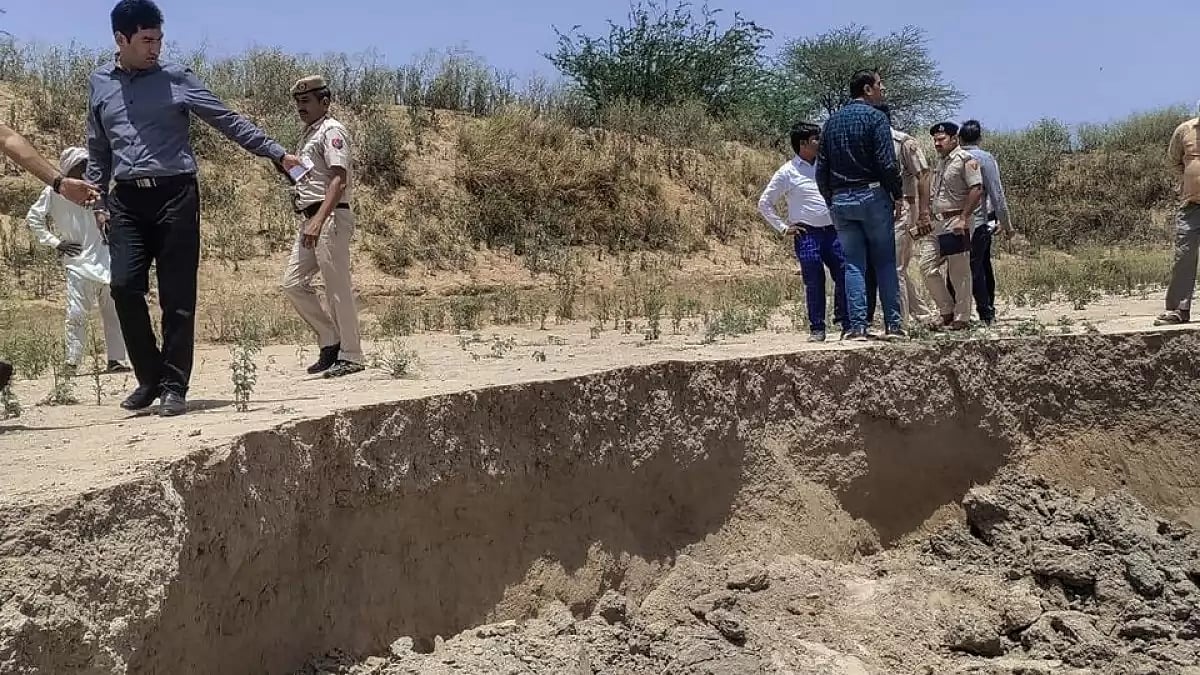 Police personnel and other officials inspect the where the mudslide took place in Gurugram