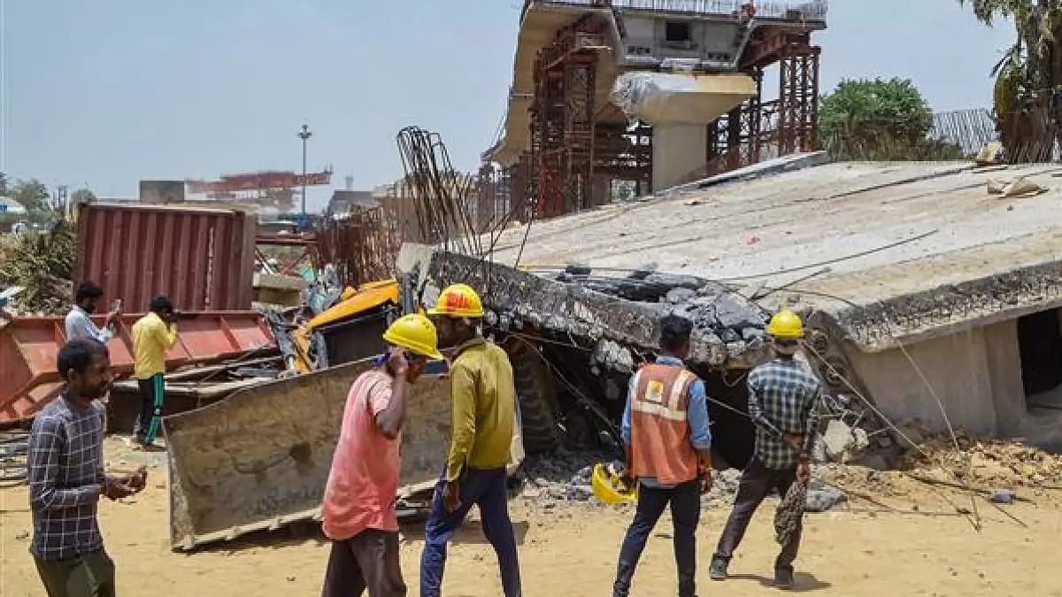 Workers at the site after a portion of an under-construction flyover collapses, in New Delhi 