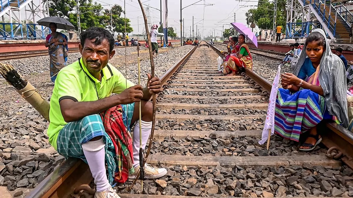 Members of Adivasi Sengel Abhiyan block railway tracks during their protest at Adina railway station, in Malda.
