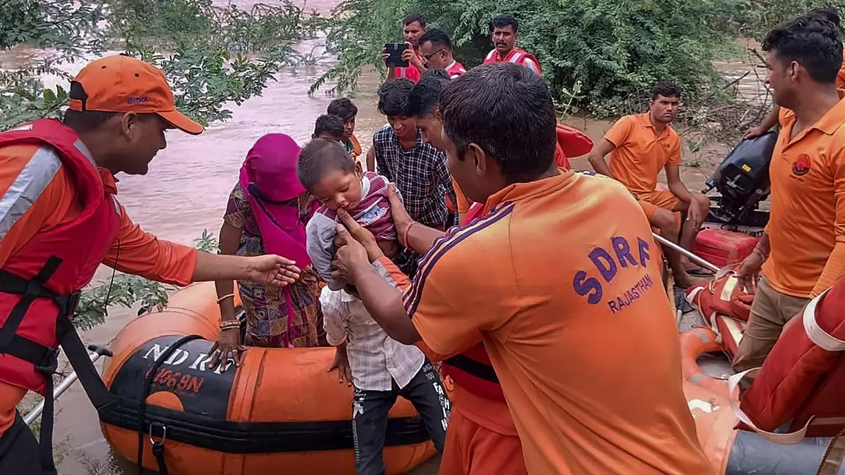 SDRF personnel rescue people living in low-lying areas of Bhinmal village after heavy rainfall under the influence of Cyclone Biparjoy, in Rajasthan's Jalore 