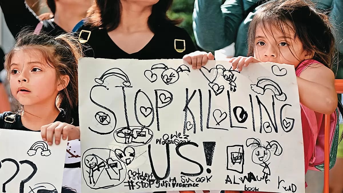 Amid Loss and Grief: A young girl holds a banner in Uvalde