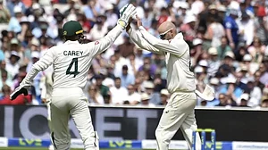 Lyon, right, celebrates the wicket of Joe Root with Carey on Monday.