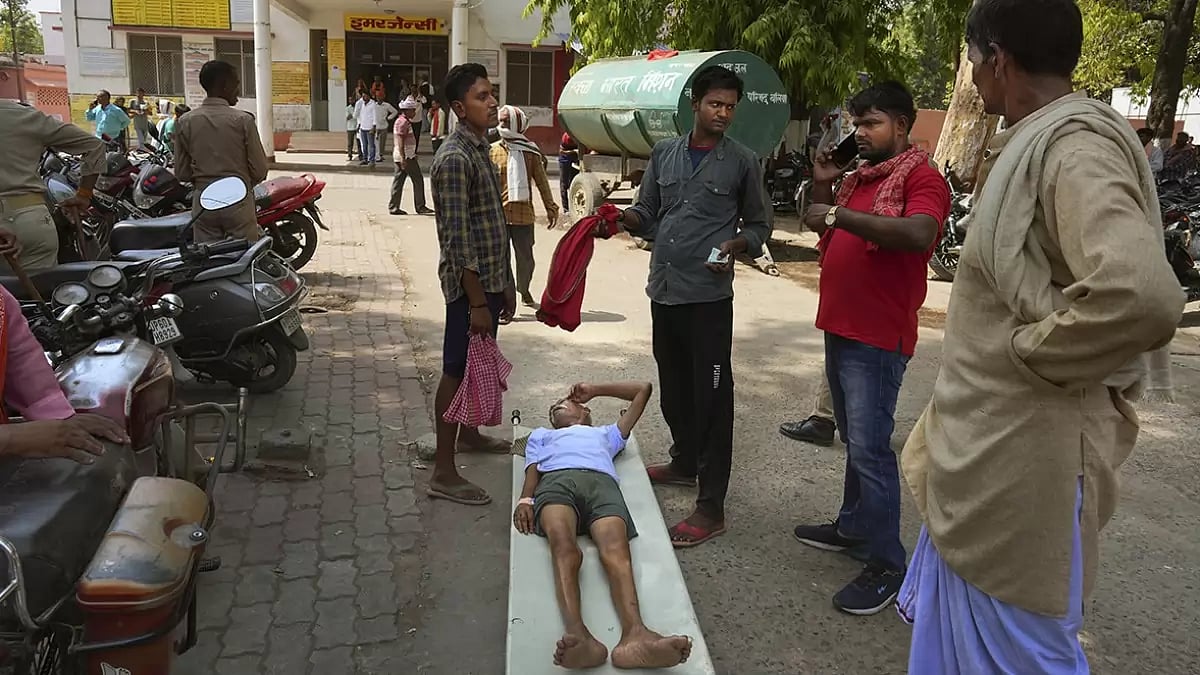 An elderly person suffering from heat related ailment lies on a stretcher waiting to get admitted outside the overcrowded government district hospital in Ballia, Uttar Pradesh.