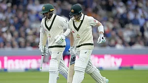 Khawaja and Smith leave the field after rain stops play on Day 3 of the 2nd Ashes Test on Friday.