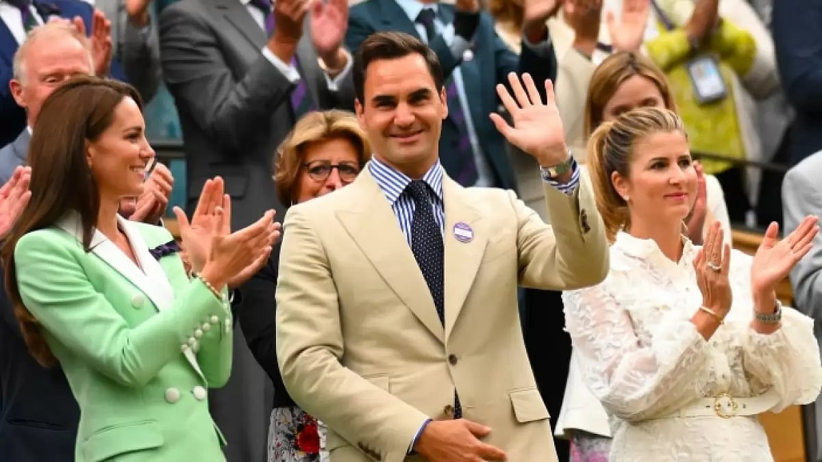 Federer waves at fans while attending Wimbledon women's match between Rybakina and Rogers.