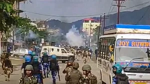 Security forces personnel lob teargas shells to disperse rioters after a mob allegedly attempted to loot weapons from an India Reserve Battalion located in Khangabok, in Thoubal district of Manipur.