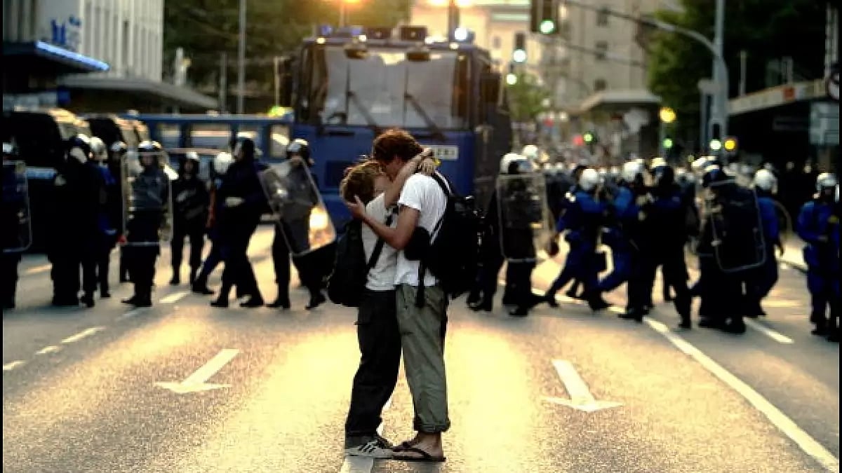 A couple kiss near a phalanx of German riot police June 2, 2003 in Geneva, Switzerland. 