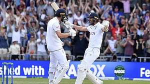 Chris Woakes, left, celebrates with Mark Wood after hitting a four to win the match on Sunday.