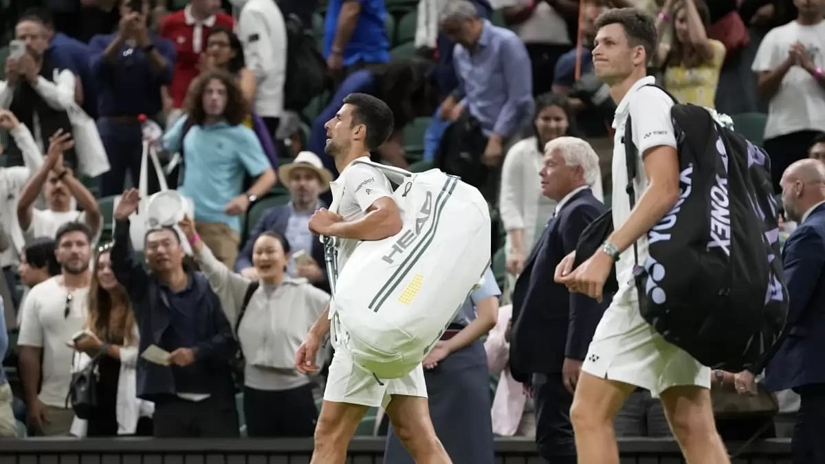 Novak Djokovic (left) walks off after his match is halted on Centre Court.