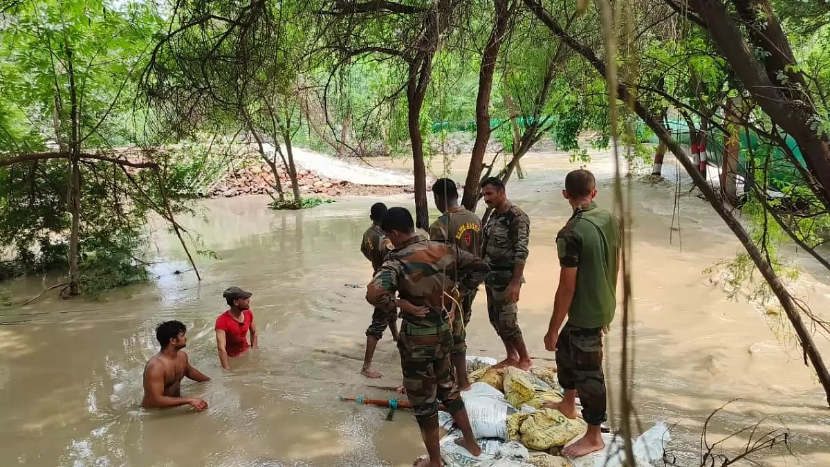 Indian Army personnel engaged in repair work at the site of a breached regulator in Delhi.