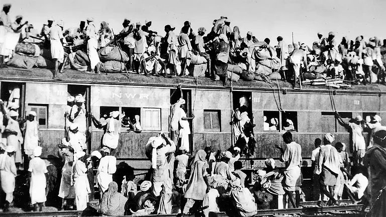 Turmoil of Partition: Refugees sit on the roof of a train trying to flee India - null