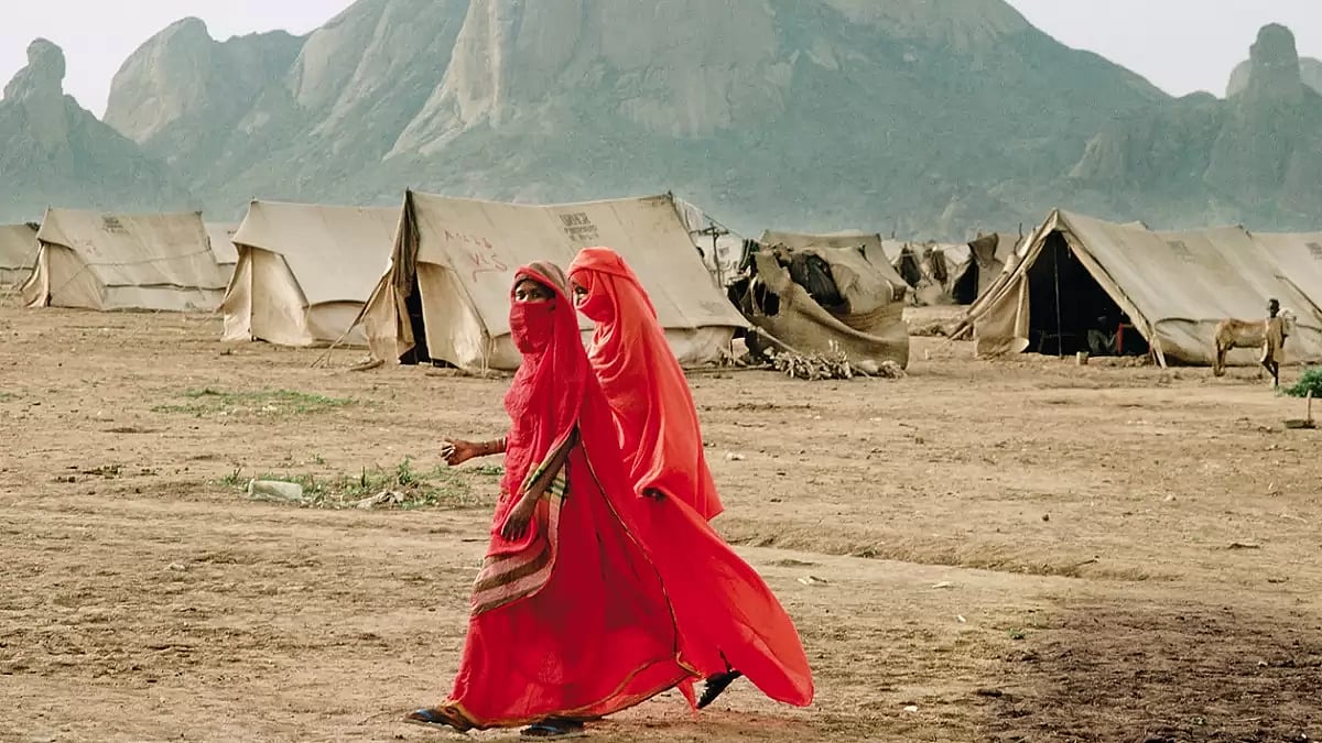 Lonely Lives: Two refugees from Eritrea, Ethiopia walk past a refugee camp in East Sudan 