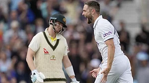 England's Chris Woakes celebrates the dismissal of Australia's Steven Smith (L)