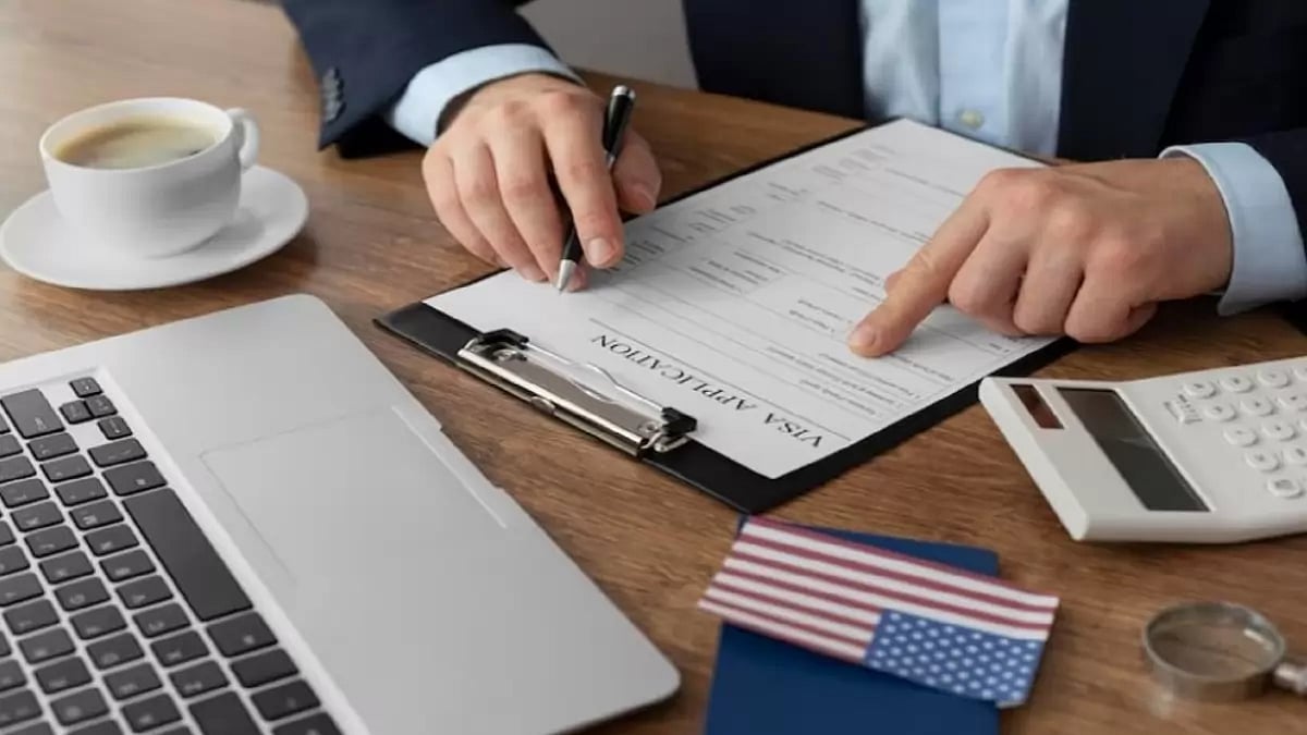 A table with laptop and visa application form 