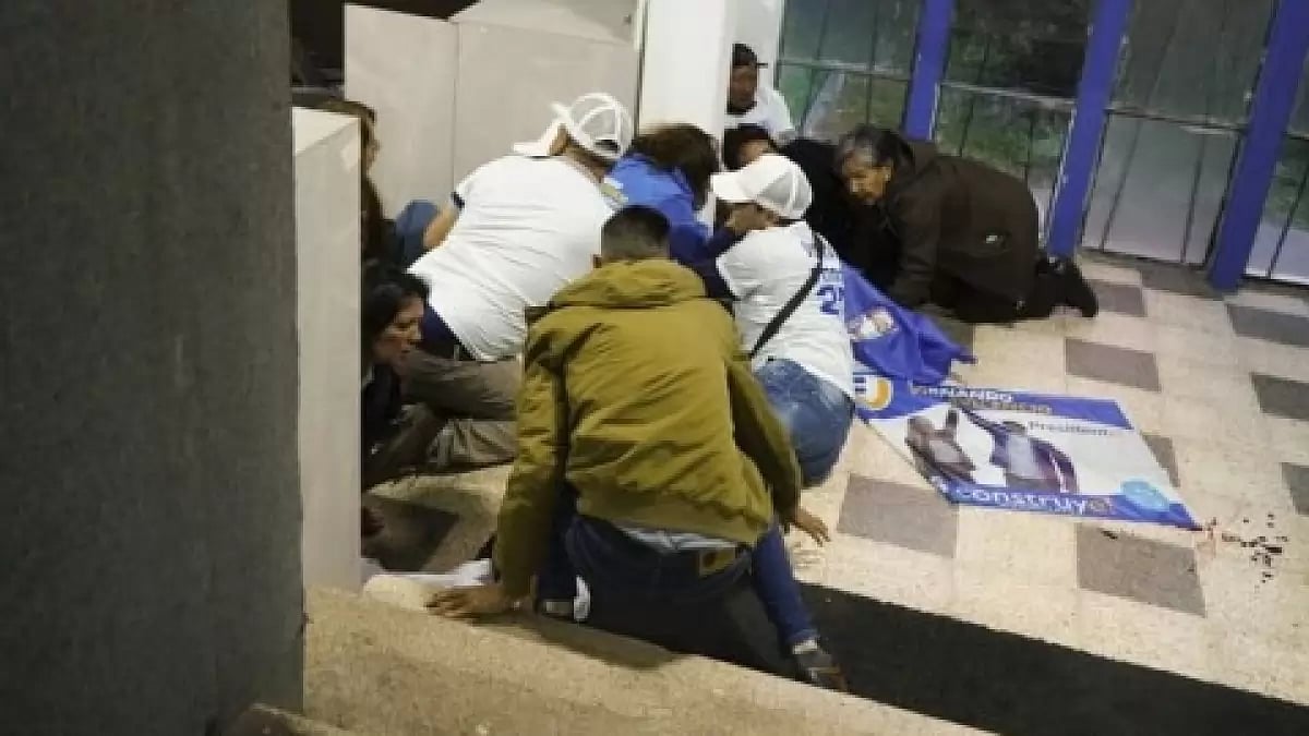 Supporters of Presidential candidate Fernando Villavicencio take cover after him being shot