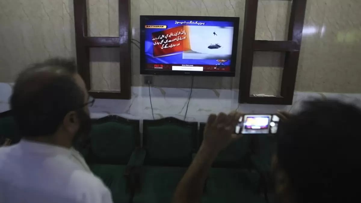 People in Pakistan watch rescue operation by Army to save people trapped in mid-air.