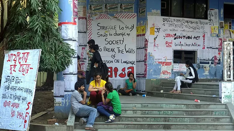 Jadavpur University students sitting on stairs. - null