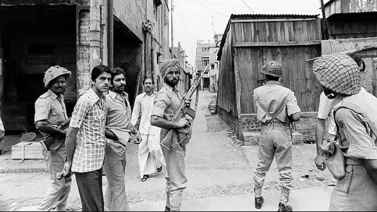 Armed policemen march in a riot torn and curfew bound street in Moradabad, Uttar Pradesh 