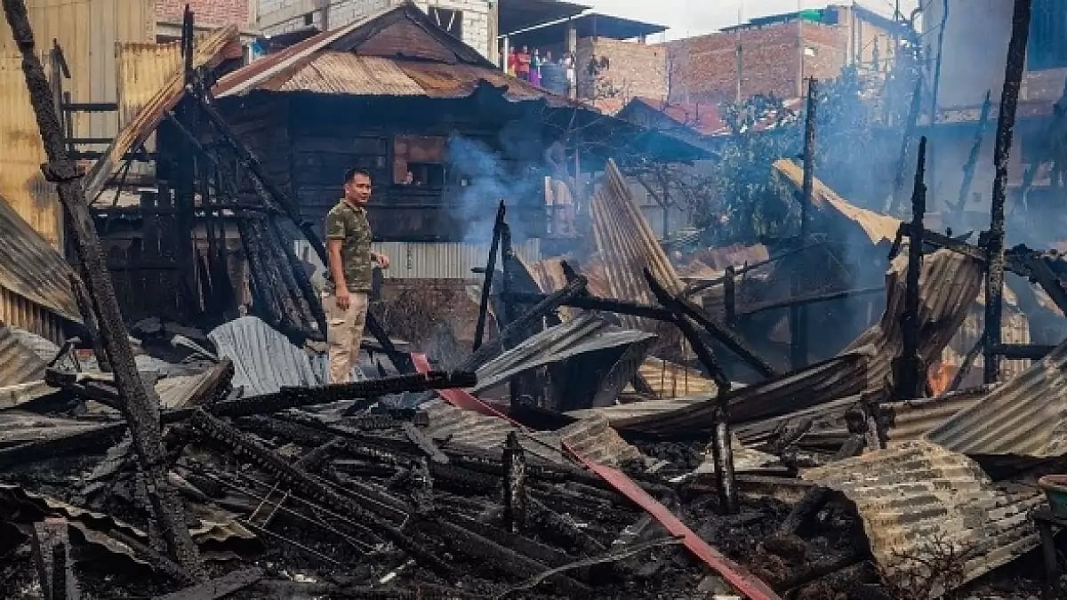A man stands amid the charred remains of houses burned down in an suspected arson attack by unknown miscreants, following ongoing ethnic violence in Imphal. (Photo: Getty Images) - null