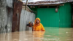 A Pedestrian walks through flooded roads in South Chittagong, Bangladesh, in high-level water.