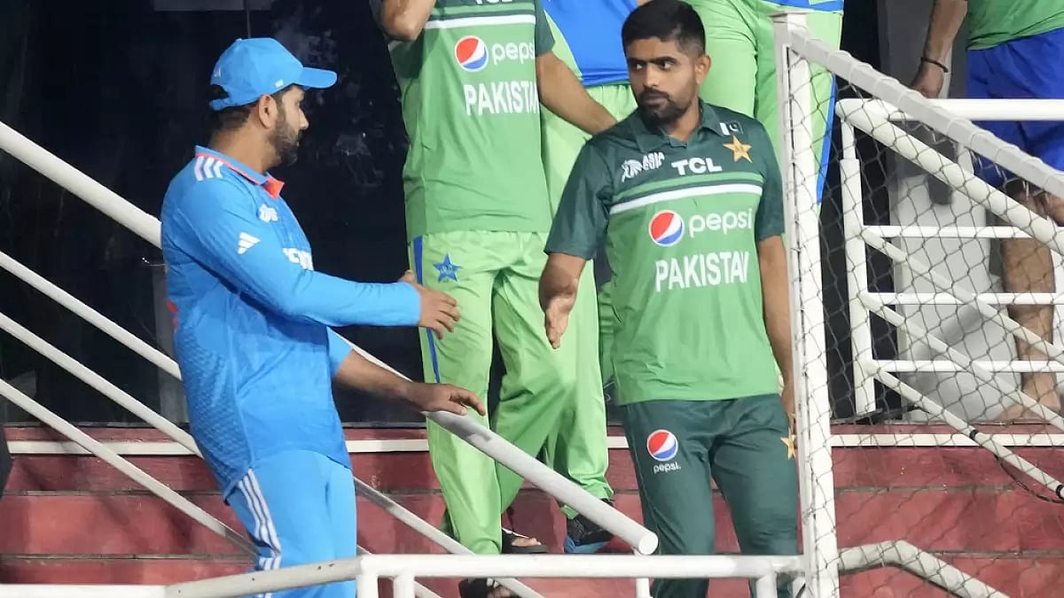 Babar Azam (R) shakes hands with Rohit Sharma after their abandoned clash in Pallekele
