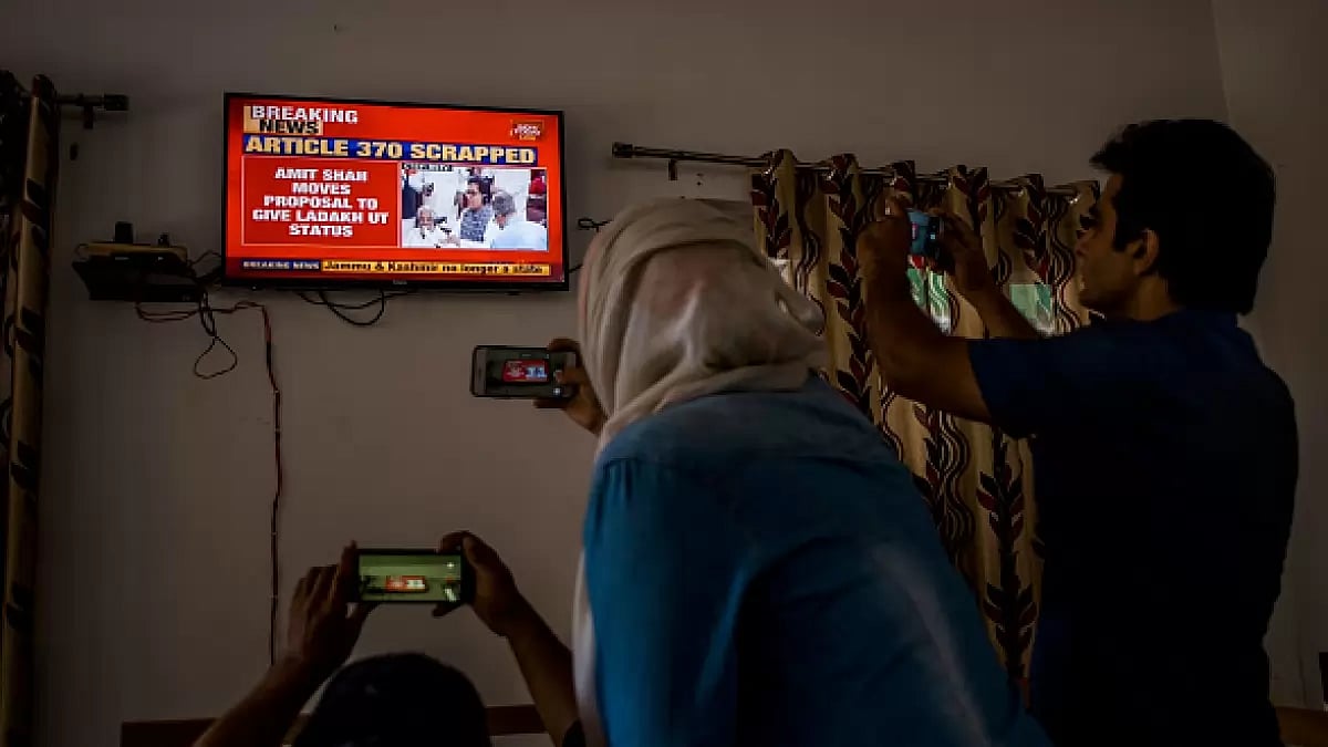 Srinagar: Journalists take pictures of a TV screen as India announces abrogation of Article 370
