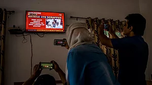 Srinagar: Journalists take pictures of a TV screen as India announces abrogation of Article 370