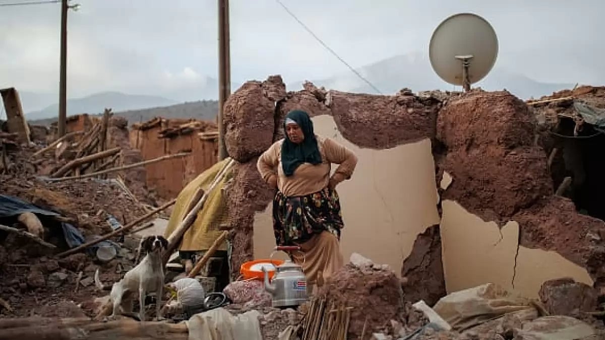 A woman cleans dishes at a tent city after 7 magnitude earthquake in Marrakesh, Morocco.