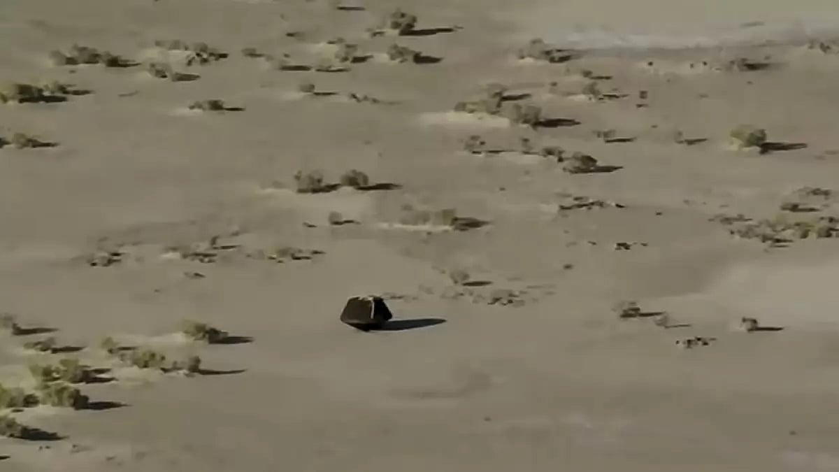 This image taken from video provided by NASA TV shows the capsule released by the Osiris-Rex spacecraft lying on the surface after landing to Earth, Sunday Sept. 24 2023. (NASA TV via AP)