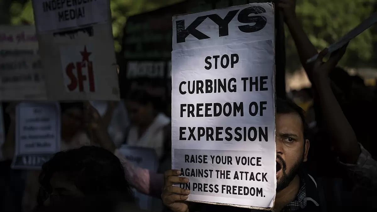 An activist shouts slogans as he holds a placard during a protest at the Press Club of India, Delhi.