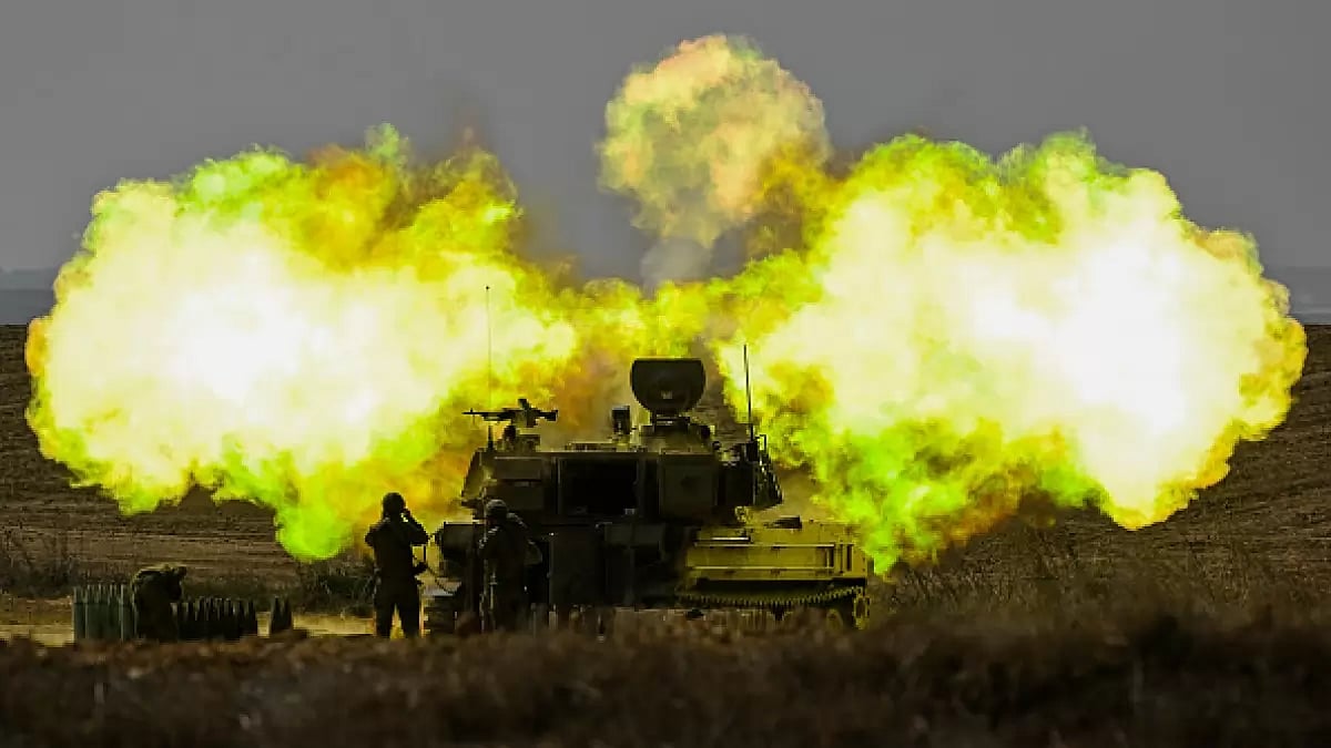  An IDF Artillery solider covers his ears as a shell is fired towards Gaza 