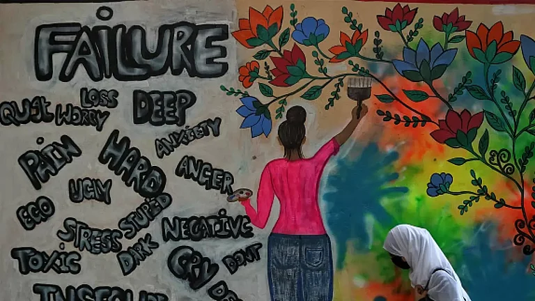 A college student walks past a graffiti on World Mental Health Day in Srinagar. - null