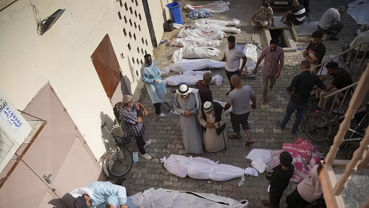 Friends and relatives stand by the bodies of Palestinians killed in the Israeli bombardment of the Gaza Strip at Al-Aqsa Hospital in Deir Al-Balah.