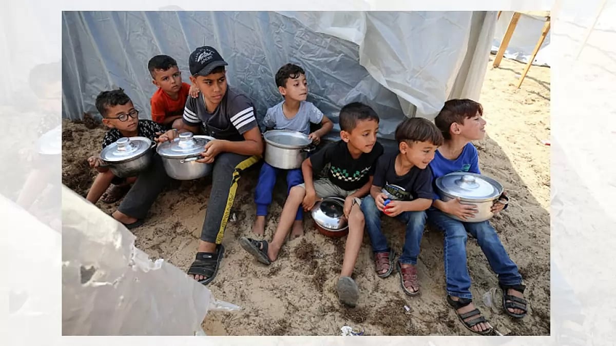 Palestinian children receive food between tents set up for Palestinians seeking refuge