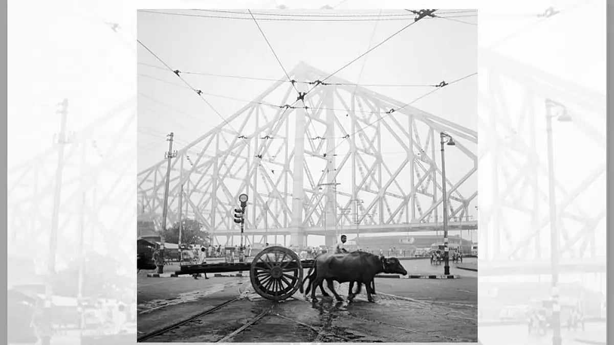 A farmer and his oxcart trudge past the girders of the Howrah bridge