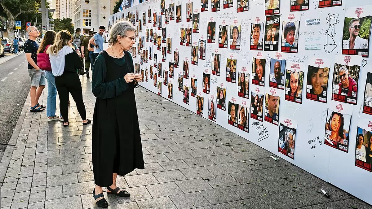 Wall of Despair: An Israeli woman looks at photos of those missing or held captive in Gaza displayed on a wall in Tel Aviv